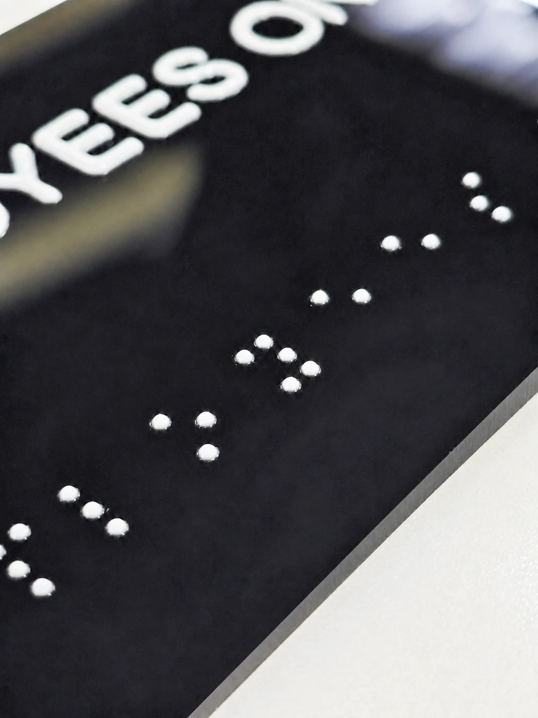 EMPLOYEES ONLY Resin Tactile Sign — Close view of the grouped white tactile dots and the panel's straight edge.